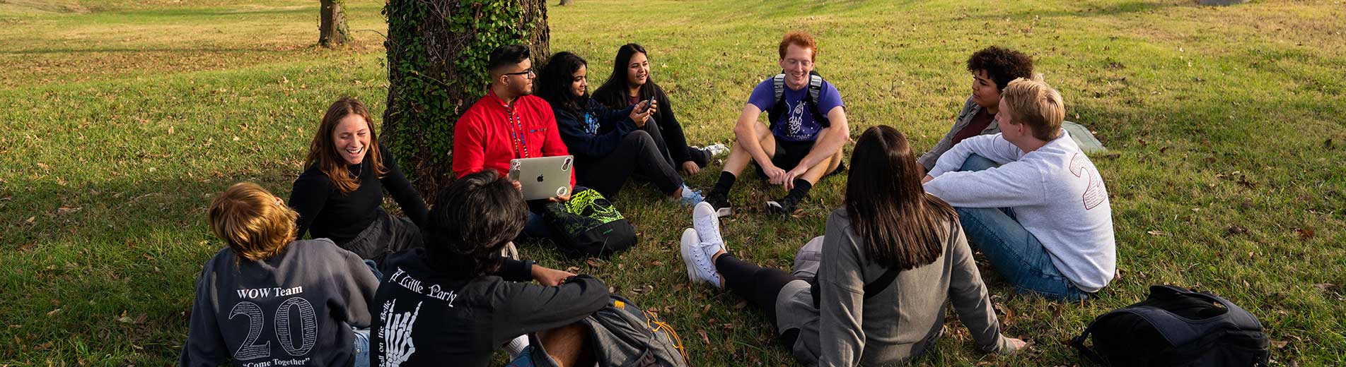 students sitting on a ground on campus