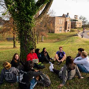 students sitting on a ground on campus