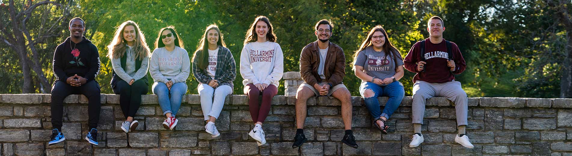 students sitting on a stone bridge